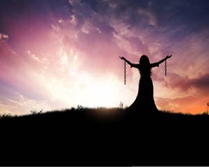 A woman in praise with her chains broken.