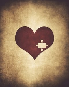 A heart on a texture background with a puzzle piece missing