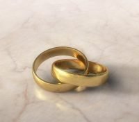 Two golden wedding rings, inseparably linked.