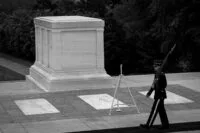 a man in uniform walking past a monument