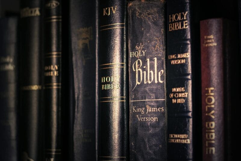 A detailed view of various King James Version Bibles, highlighting religious imagery.