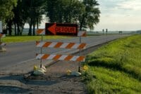Roadside detour sign with arrow in rural Plainview, MN, under clear skies. Perfect for travel and road maintenance themes.